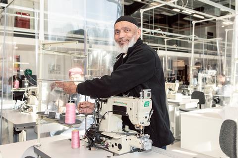 Male garment worker using a sewing machine at Boohoo model factory, Leicester